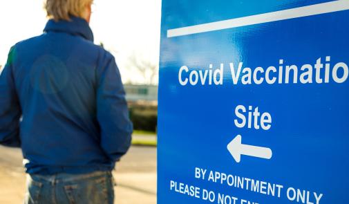 sign shows the direction to a covid vaccination site