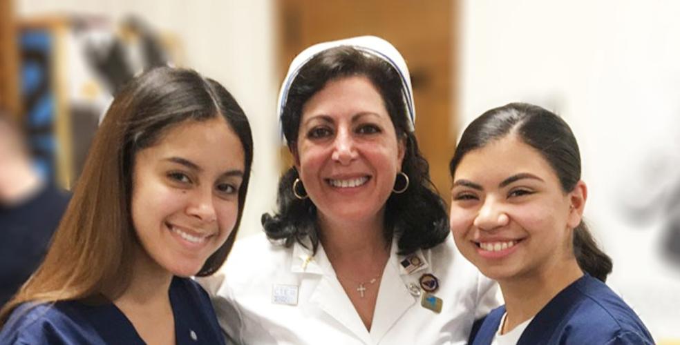 Photo of Linda Romano, center, with two of her students