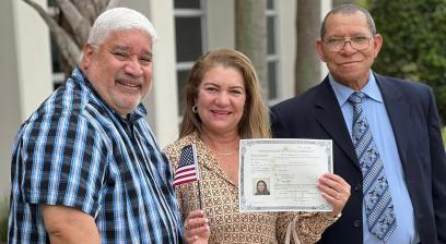 AFT member Mercedes Caceres, center, after her citizenship ceremony with HSEF President Iran Alicea, left, and Victor Moreno, also of HSEF, right. 