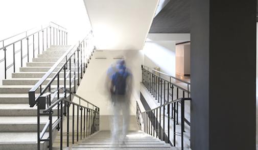 a student, not in focus, walks in a school building