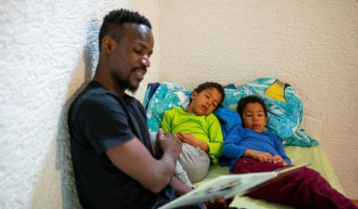 Padre leyendo a dos niños