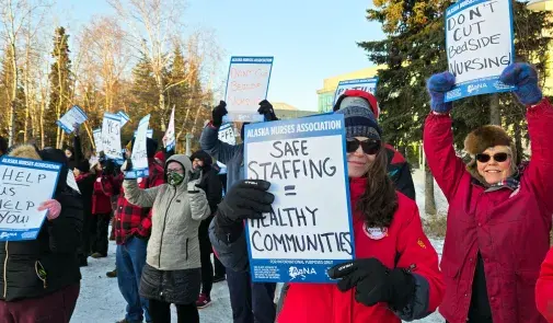 Members holding up signs that read "Alaska Nurses Association: Safe Staffing = Healthy Communities", "Help Us Help You", "Don't Cut Bedside Nursing" and more