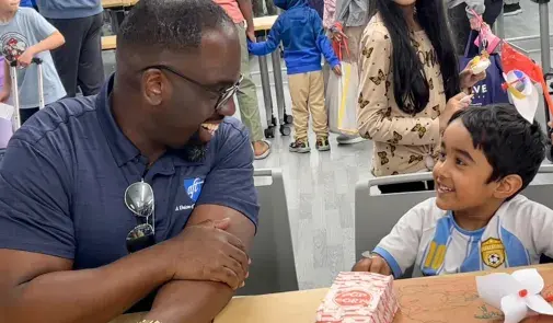  AFT Secretary-Treasurer Fedrick C. Ingram smiling with child