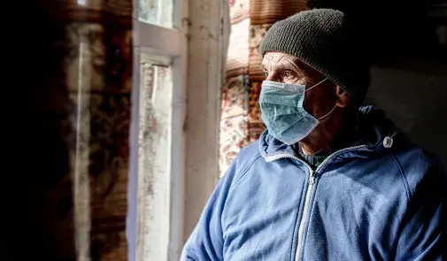 Man in medical mask looks to the left
