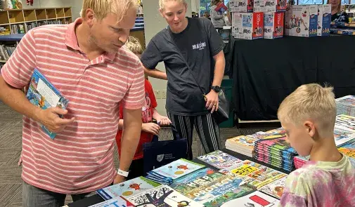 Looking at books at a meet-the-teacher night in Elk Valley Elementary School in Lake City, Pa.