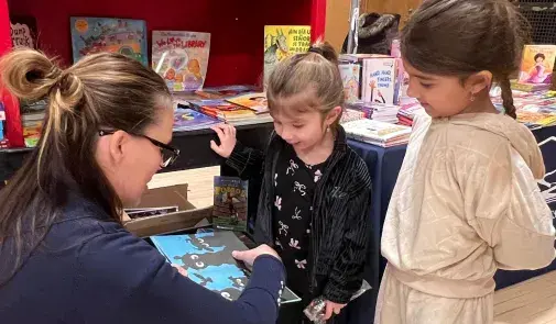 Rheagan and Aurora Saravia, ages four and six, were captivated by the books at the Liberty Faculty Alliance's Reading Opens the World event.