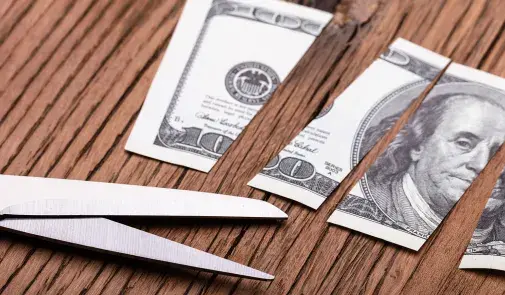 scissors and a cut up hundred dollar bill