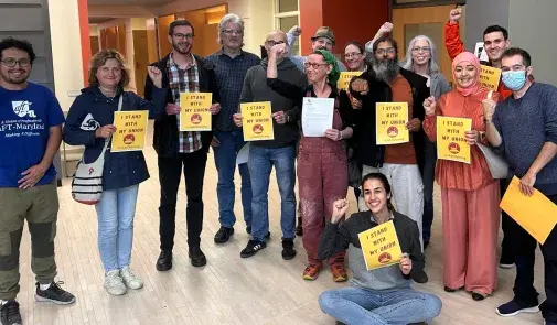 Faculty at the Community College of Baltimore County posing together with signs that say "I stand with my union"
