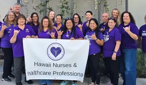 Members in purple shirts hold sign that reads "Hawaii Nurses & Healthcare Professionals"