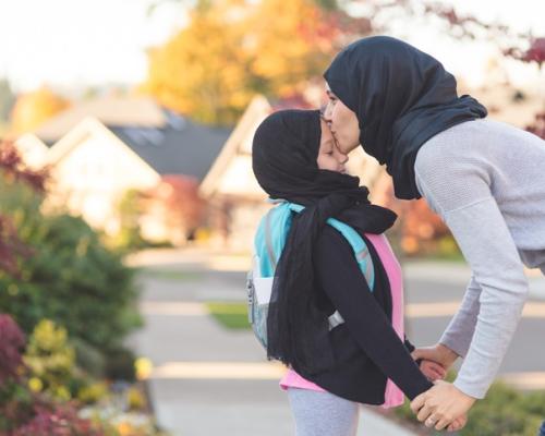 Photo of mom kissing forehead of child