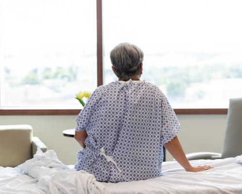 Getty Images hospital patient sitting on bed facing window