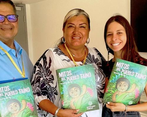 Author Evelyn Taino posing with two adult readers, all holding copies of her book