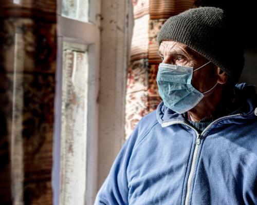 Man in medical mask looks to the left