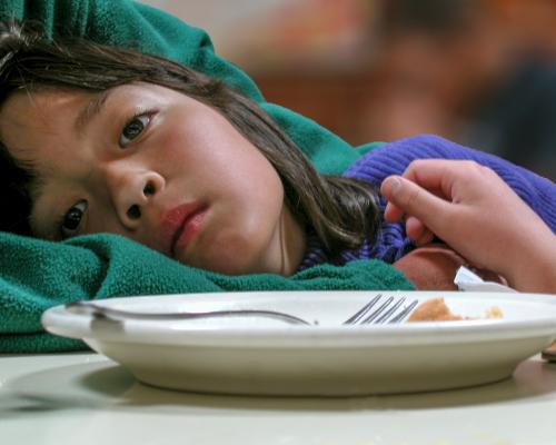 Tired girl with an empty plate