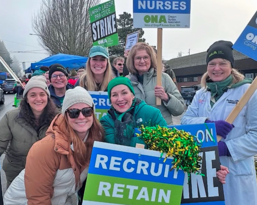 Group of striking clinicians pose with picket signs