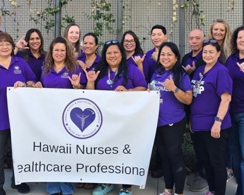 Members in purple shirts hold sign that reads "Hawaii Nurses & Healthcare Professionals"