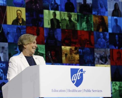 AFT President Randi Weingarten standing behind podium, smiling, delivering speech