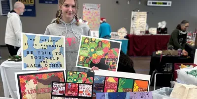 Photo of Ryan Lomber and some of her art