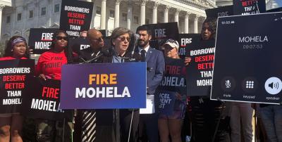 AFT President Randi Weingarten speaking to press at an outdoor conference surrounded by signs and people supporting the FIRE MOHELA movement
