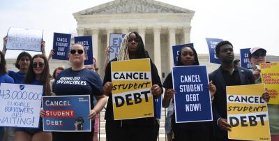 People holding signs that read "Cancel Student Debt." OLIVIER DOULIERY / Contributor / AFP / Getty Images