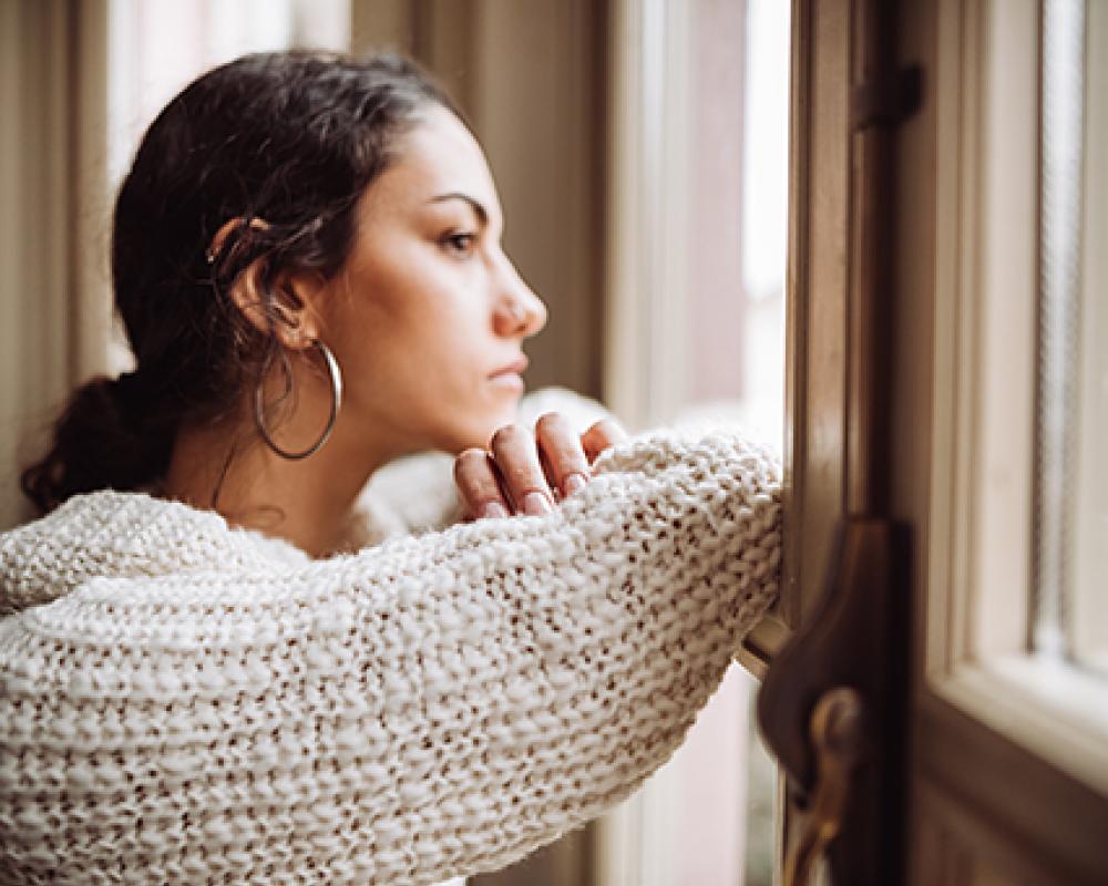 Photo of woman looking out a window
