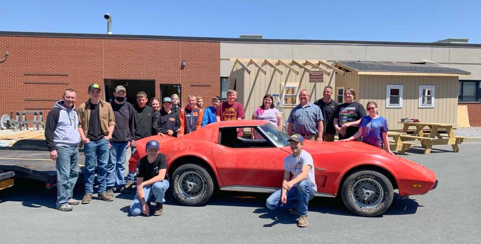 Photo: Berne-Knox-Westerlo CTE Teachers Josh Baker (fourth from right) and Bill Dergosits (third from right) with their students. The class is using their training to restore the 1976 Corvette Stringray, which will be auctioned off to raise funds for the district’s growing CTE program.