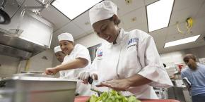 Foto de chefs preparando comida en una cocina.