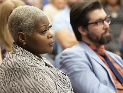 dos profesores de escuelas públicas, una mujer afroamericana y un hombre blanco, se sientan y escuchan