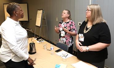 three women discuss at the workshop