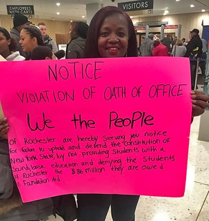 black woman holding pink sign