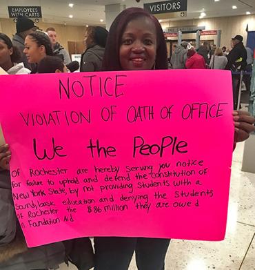 black woman holding pink sign