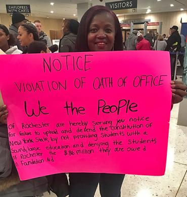 black woman holding pink sign