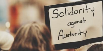 person holds sign that says solidarity against austerity