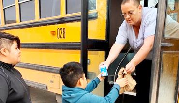 conductor de autobús dando comida infantil