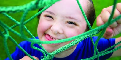 young child with downs syndrome smiles