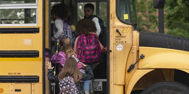 children getting on the school bus