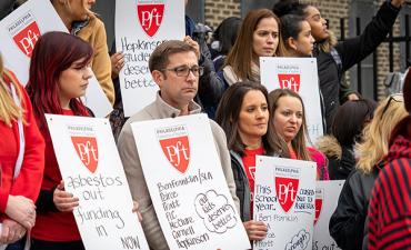 crowd at pft rally looks somber while holding signs