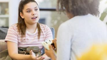 young woman explains to a person not facing the viewer