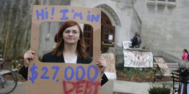 woman holding up sign about her student debt