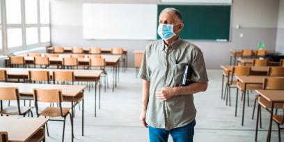 teacher wearing mask in empty classroom