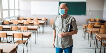 maestro con máscara en el aula vacía