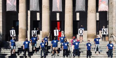 people spell union on the steps with signs