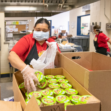 a woman. Alma Garcia, sorts food in a cardboard box