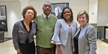 a group of three black people stand with a white woman