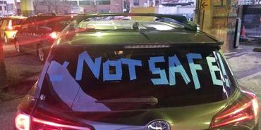 not safe spelled out in tape on the back window of a car