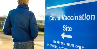 sign shows the direction to a covid vaccination site