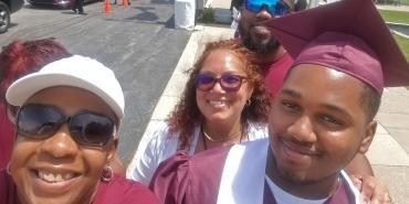 a black woman, Cerssandra McPherson, stands with one of her students and smiles