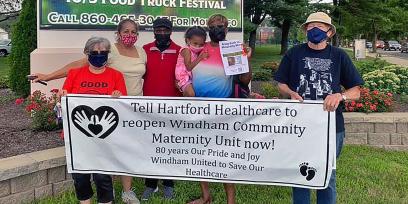 Personas con cartel instando a Hartford Healthcare a reabrir la unidad de maternidad de Windham