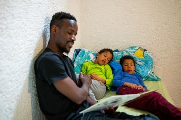 Padre leyendo a dos niños