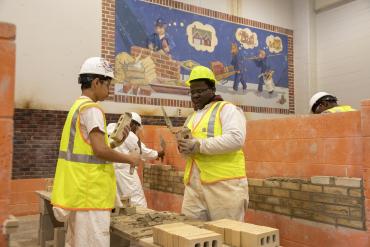 Foto de estudiantes realizando un proyecto de construcción práctico.